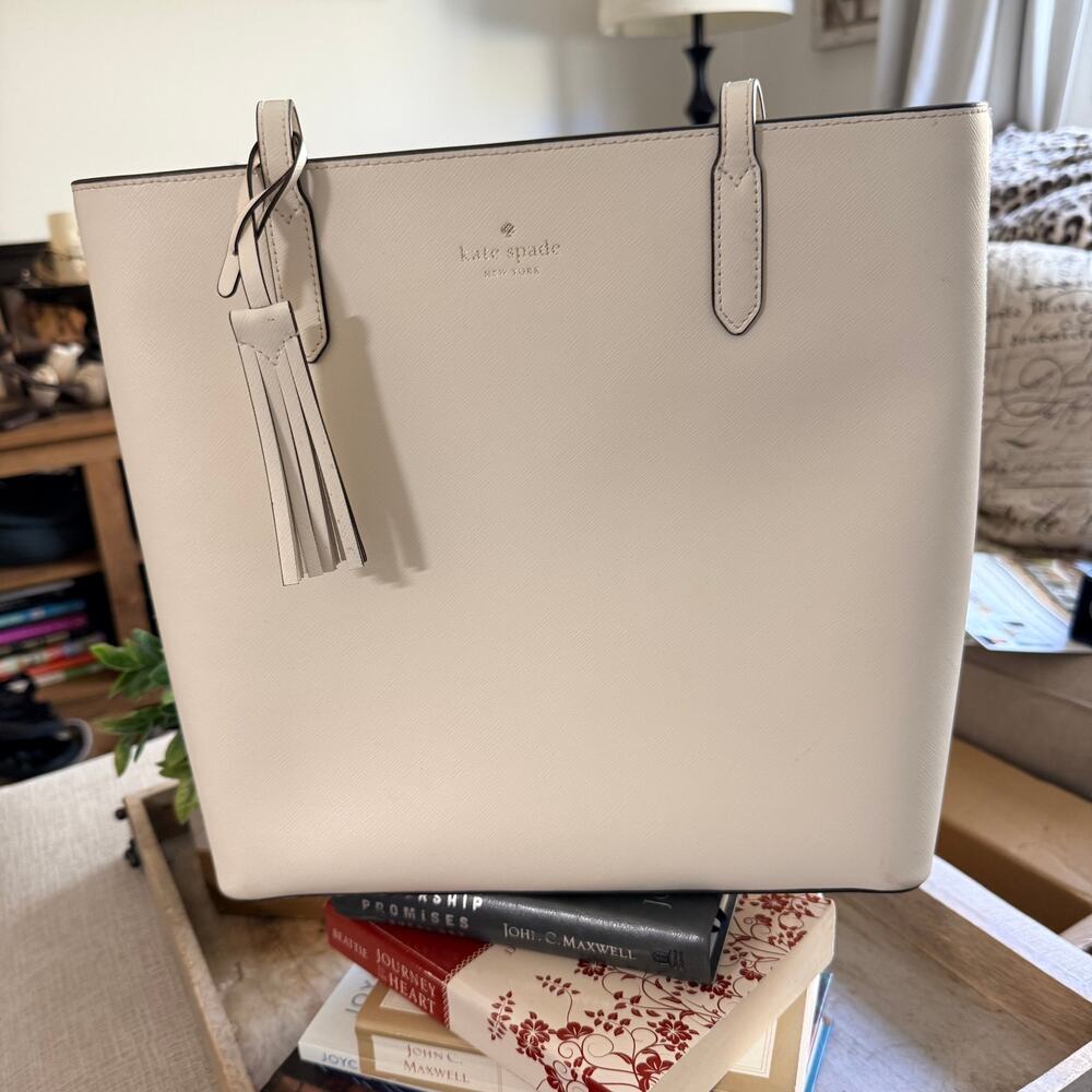 Cream-colored Kate Spade Jana Tote with leather tassel detail on the side.